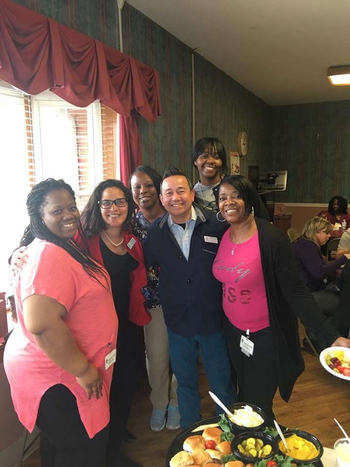 A group of people smiling together at an indoor social event.