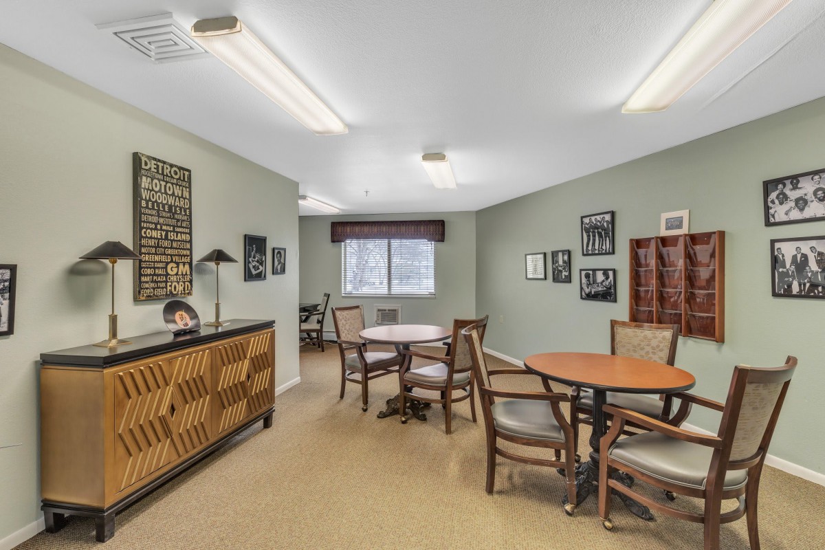 A well-furnished office space with tables, chairs, and decorative artwork on the walls.
