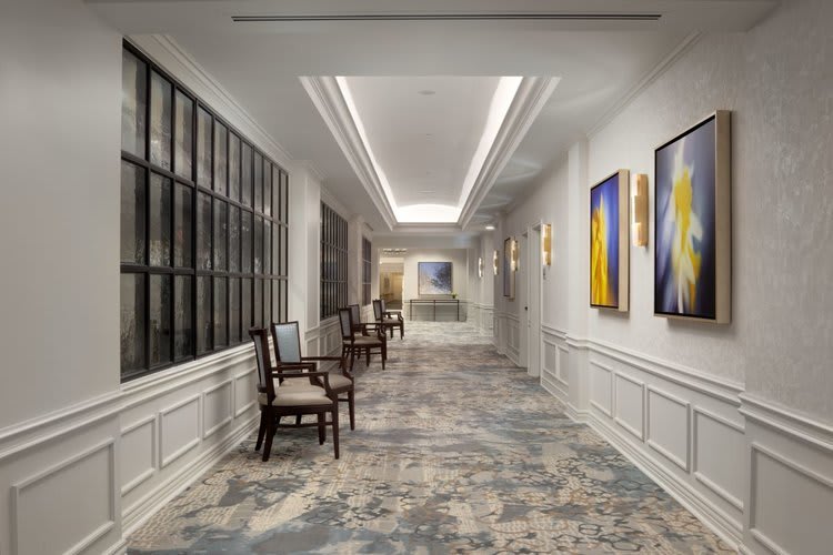 A well-designed hallway featuring elegant chairs and modern artwork.