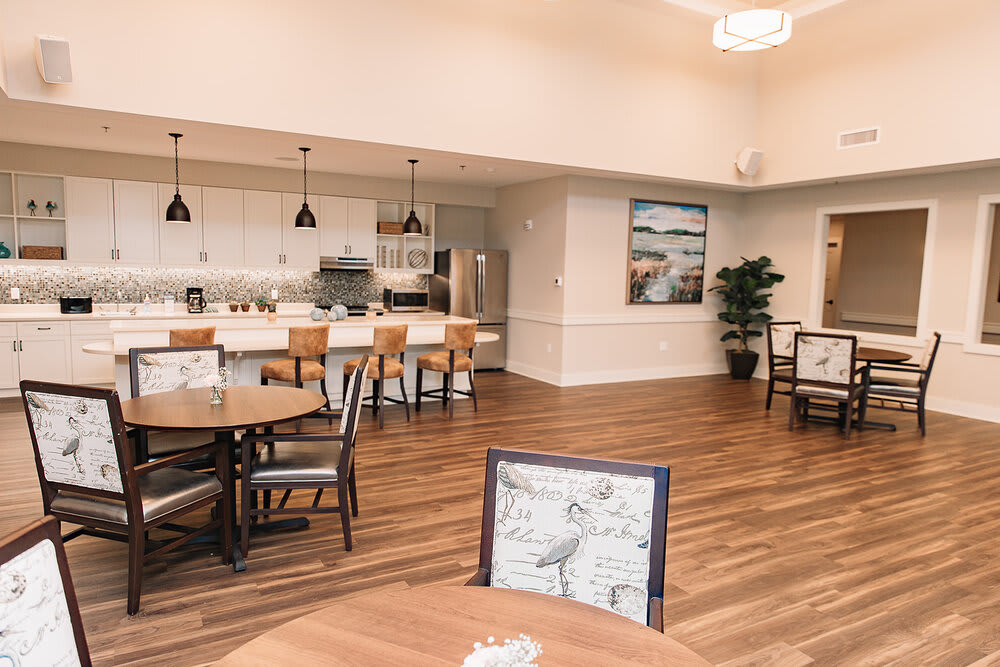 A modern kitchen and dining area with wood flooring and bar stools.