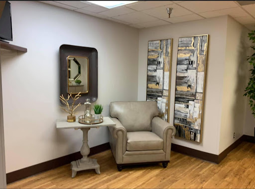 A cozy corner of a modern living room featuring elegant furniture and stylish wall art.