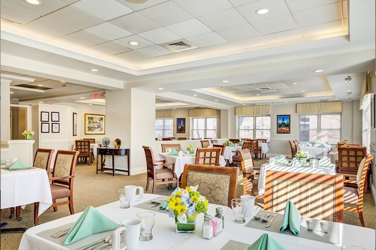 A spacious and elegantly decorated restaurant dining room with neatly arranged tables and chairs.