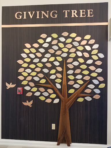 A decorative wall art featuring a tree with colorful leaves and birds.