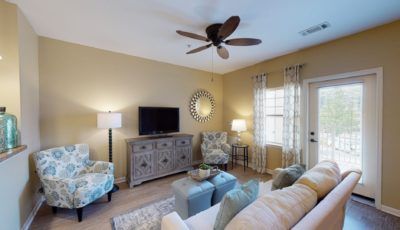 A cozy living room with modern decor, featuring a comfortable sofa, television, and stylish furniture.
