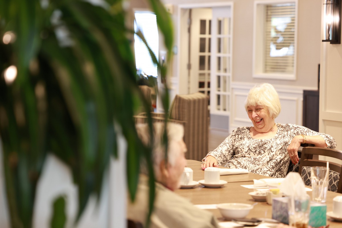 A small group of elderly people enjoying a conversation in a cozy indoor setting.