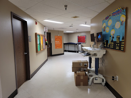 A view of a hospital hallway featuring colorful artwork and a medical cart.