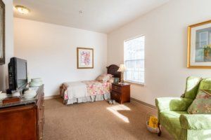 A cozy bedroom with a single bed, side table, and window allowing natural light.