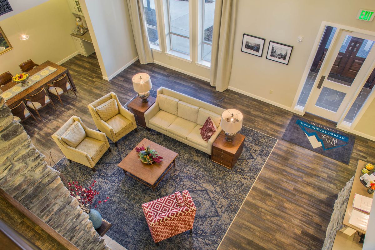 A stylishly decorated living room featuring a comfortable seating arrangement with a sofa, armchairs, and a coffee table on a patterned rug.