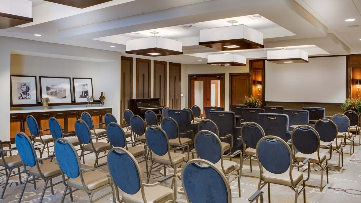 A modern and empty conference room set up with rows of chairs.