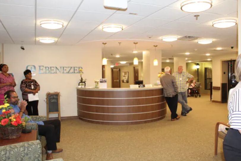 A modern reception area with a curved front desk and people interacting.