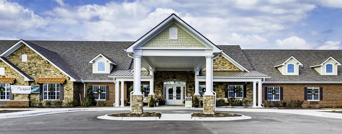 A welcoming building entrance with columns and a covered porch.