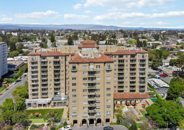 Aerial view of a high-rise residential building set against an urban backdrop.