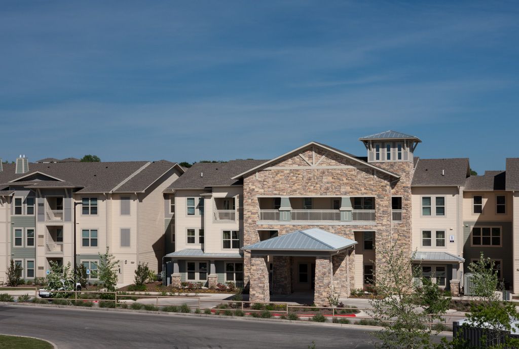 A modern residential building with a stone facade and multiple stories.