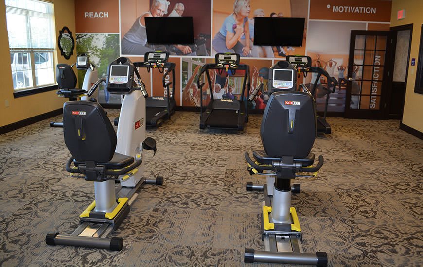 A gym with stationary bikes and treadmills ready for use.