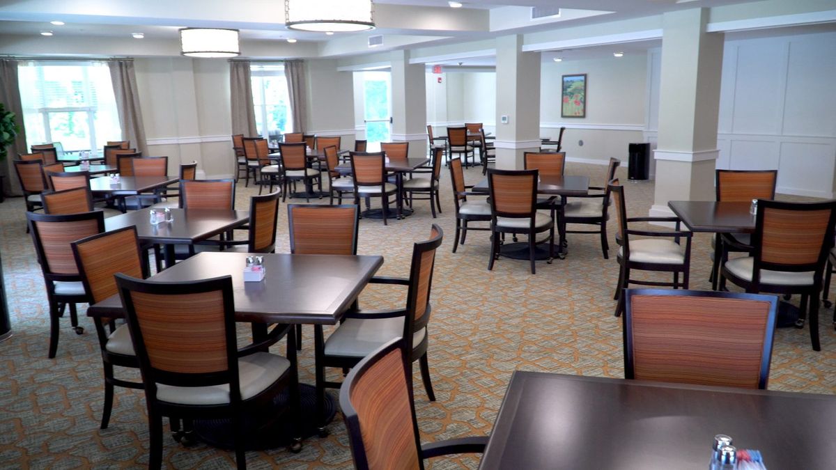 An empty dining room with arranged tables and chairs.
