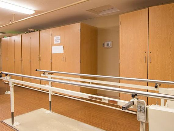 A rehabilitation room equipped with parallel bars for physical therapy exercises.