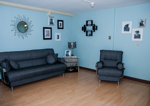 A cozy living room featuring a blue color scheme, modern furniture, and decorative wall art.