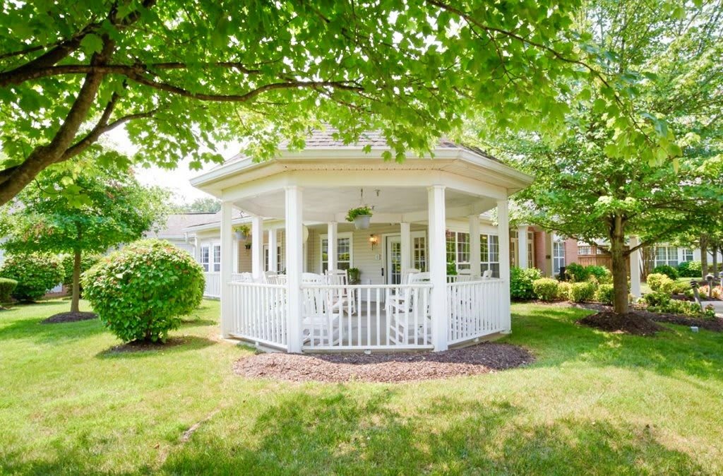 A charming white gazebo nestled in a lush garden.