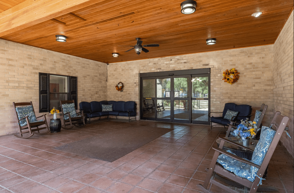 A cozy patio with rocking chairs and a wooden ceiling, offering a tranquil outdoor seating area.