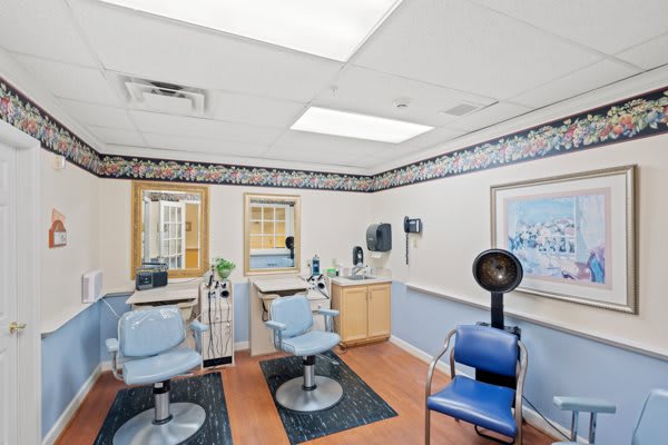 A well-equipped hair salon with chairs, mirrors, and a hair dryer.