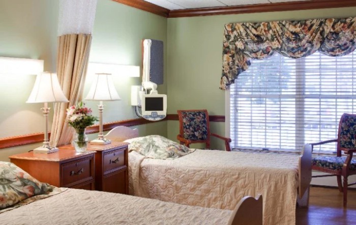 A well-lit hospital room with twin beds and elegant decor.