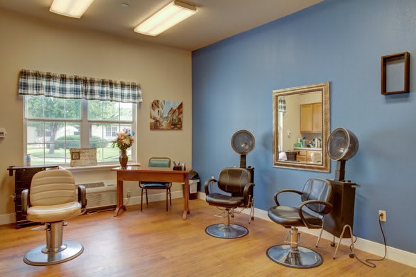 A cozy hair salon interior with styling chairs, mirrors, and a blue accent wall.