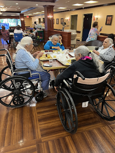 A group of seniors in wheelchairs enjoying a meal together, fostering community and social interaction.