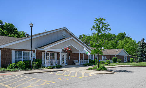 A community building with a parking lot and accessible parking spaces on a sunny day.