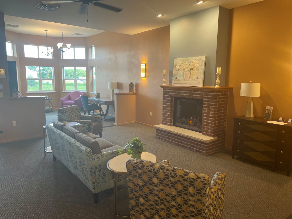 A cozy living room with a fireplace, sofas, chairs, and decorative elements.