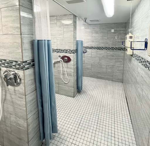 A modern and clean shower area with tiled walls and curtains for privacy.