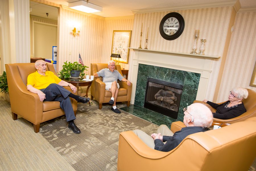 A group of elderly men having a conversation in a cozy living room.