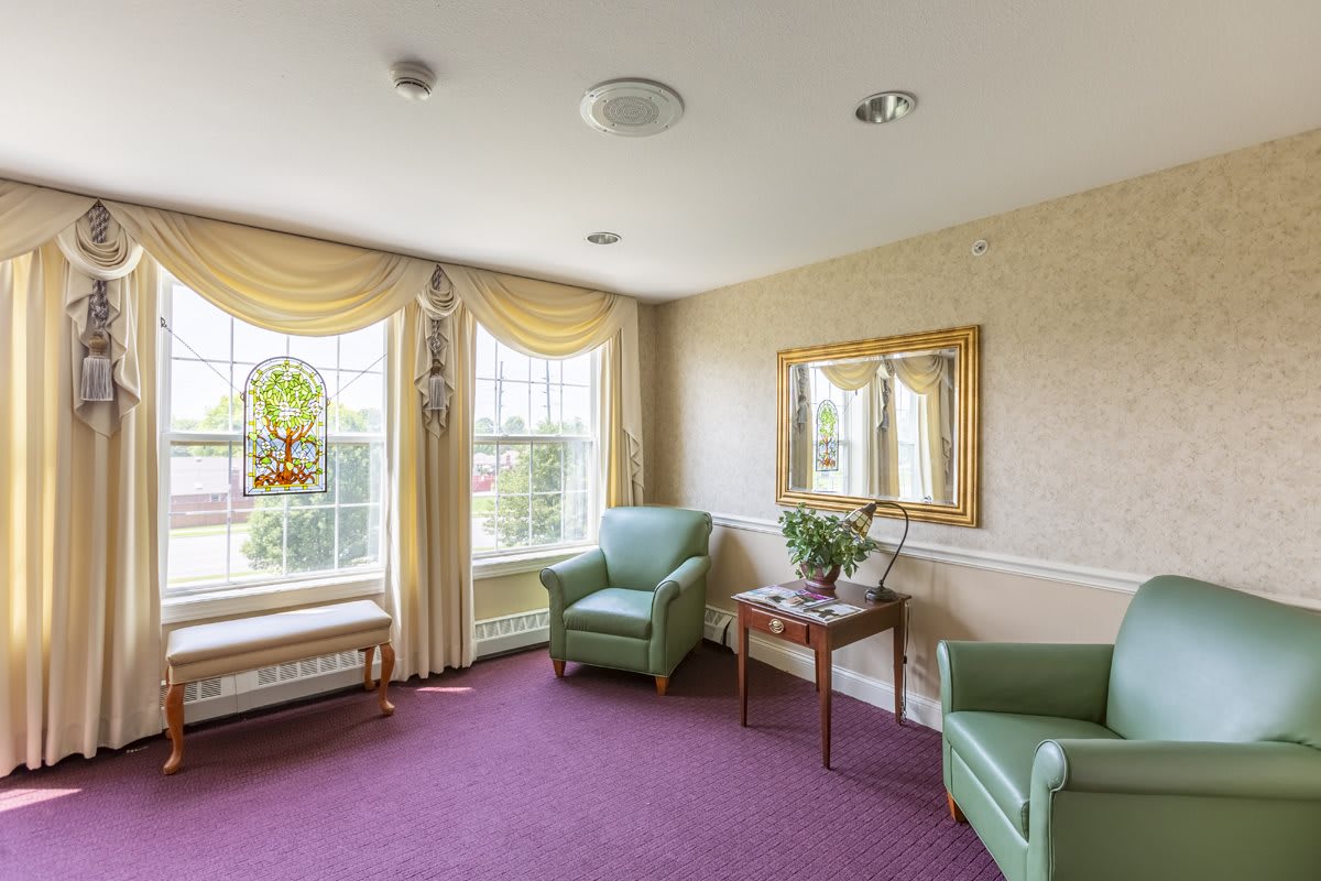 A cozy living room corner with comfortable chairs and large windows.