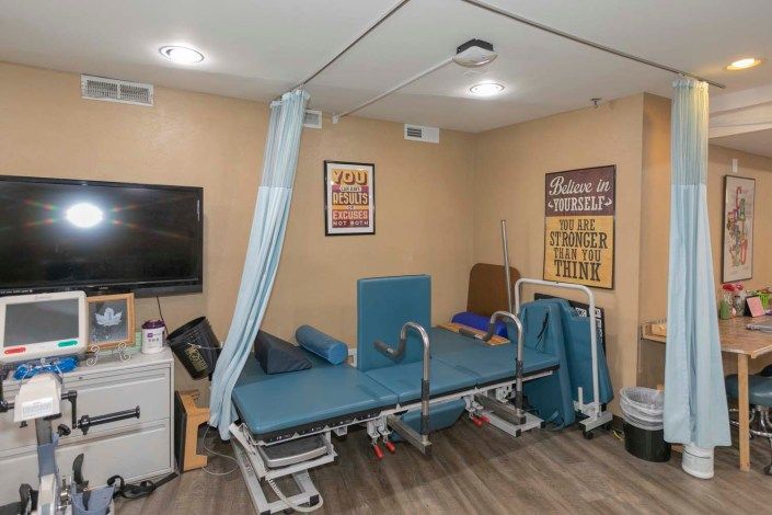 A therapy room equipped with a treatment table and medical equipment.