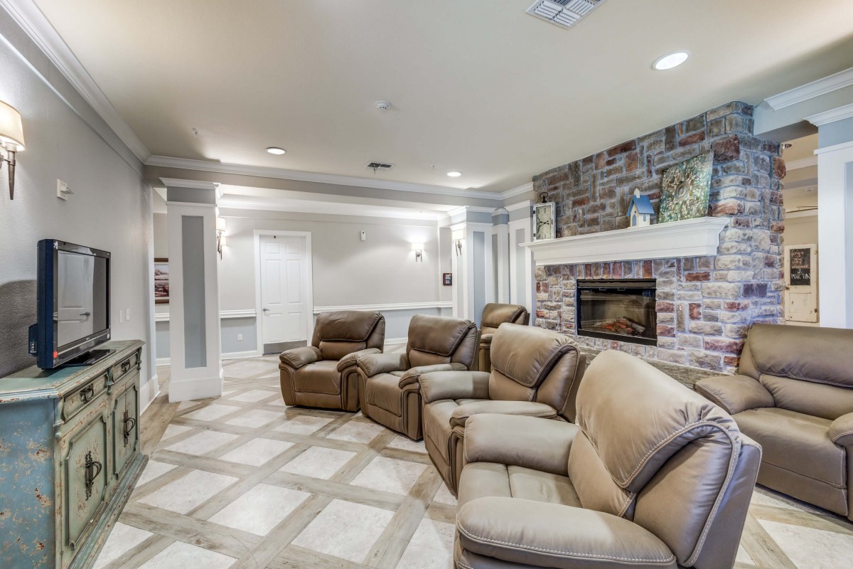 A cozy home theater setup with recliner chairs and a fireplace.