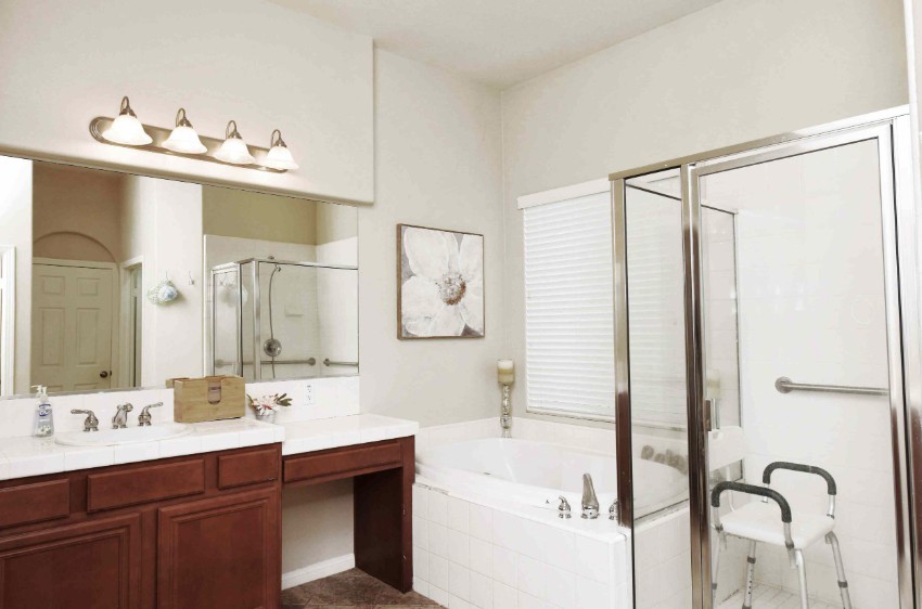 A modern bathroom with a bathtub, glass shower, and vanity area.
