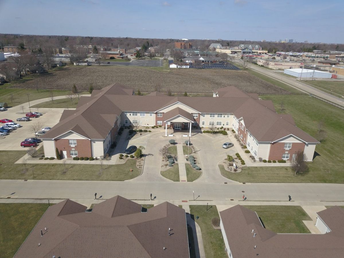 Aerial view of a large building complex with surrounding open land.