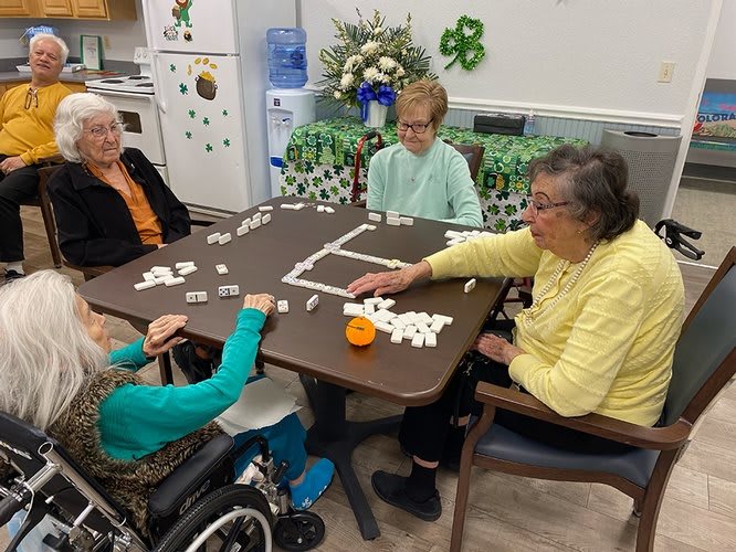 A group of seniors playing dominoes together at a community center.