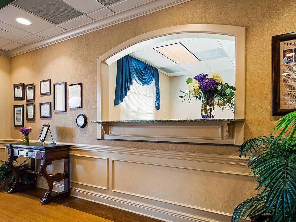 A welcoming reception area with a front desk, floral arrangement, and elegant decor.
