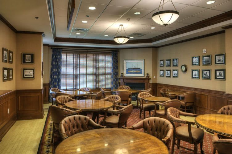 A cozy lounge area with wooden tables and chairs arranged for a meeting or gathering.