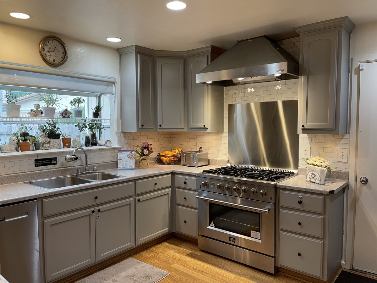 A modern kitchen with stainless steel appliances and gray cabinets.