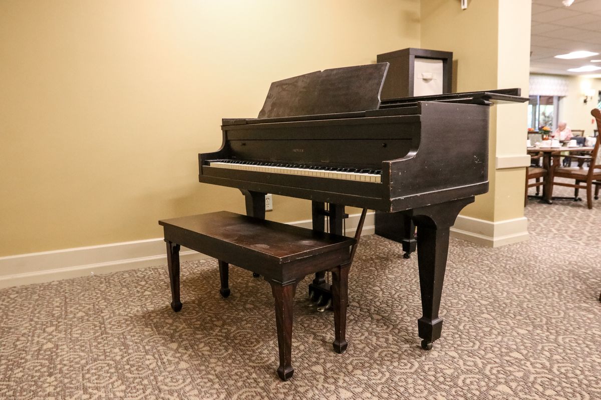 A classic piano with a matching bench in an indoor setting.