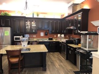 A modern kitchen with dark cabinets and a spacious countertop layout.