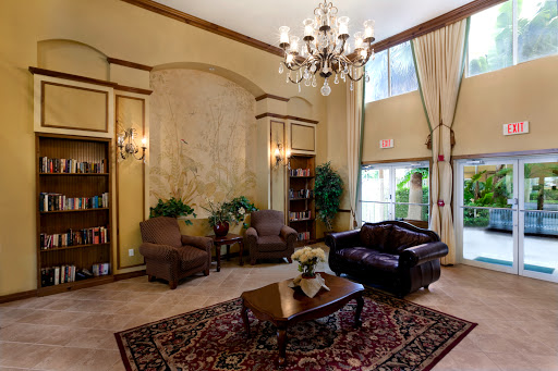 A cozy and elegant lobby featuring comfortable seating, decorative plants, and a stylish chandelier.