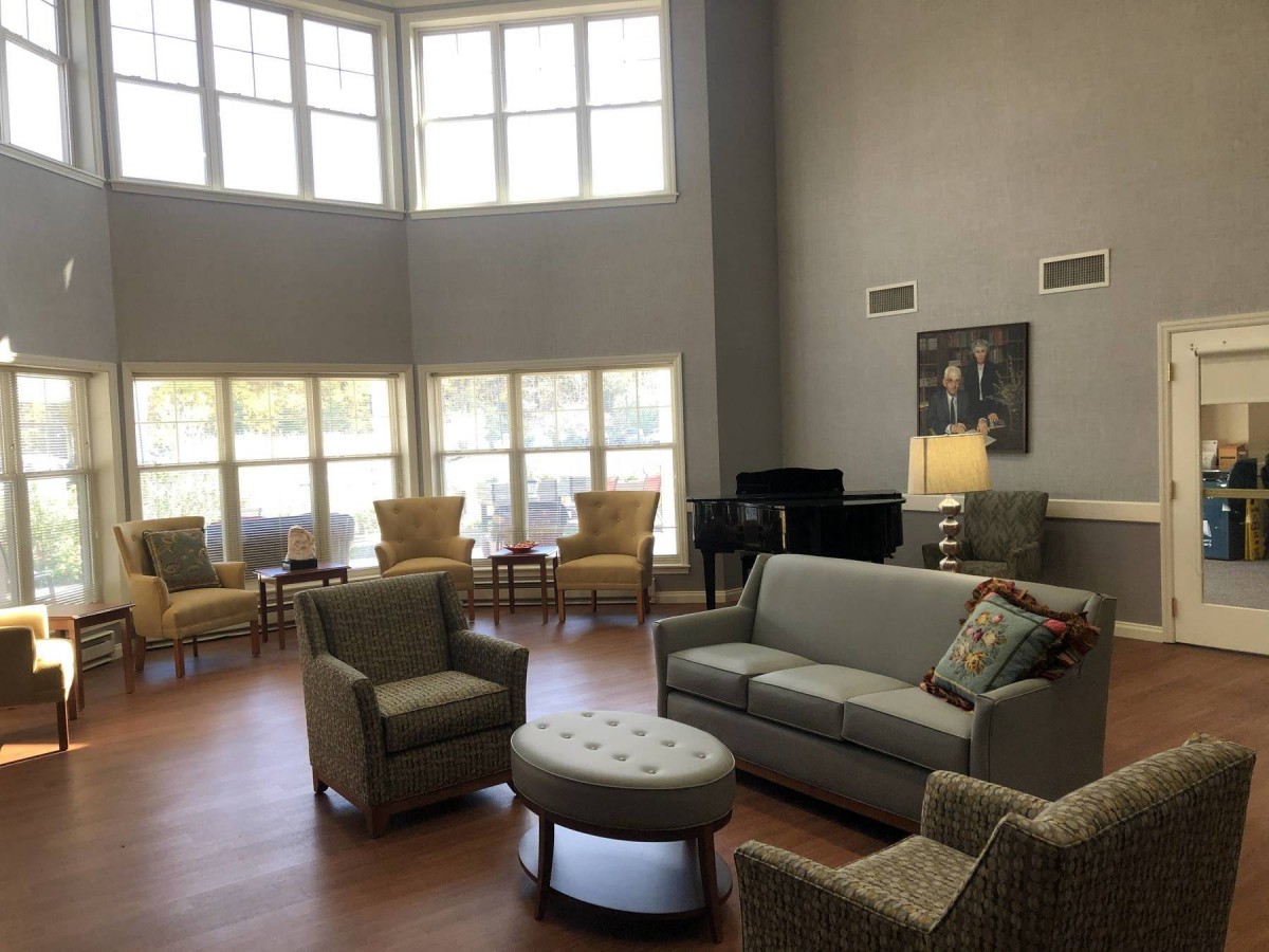 A spacious, well-lit living room featuring modern furniture and large windows.