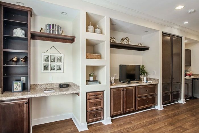 A well-organized living space featuring built-in shelves, a desk area, and stylish cabinetry.