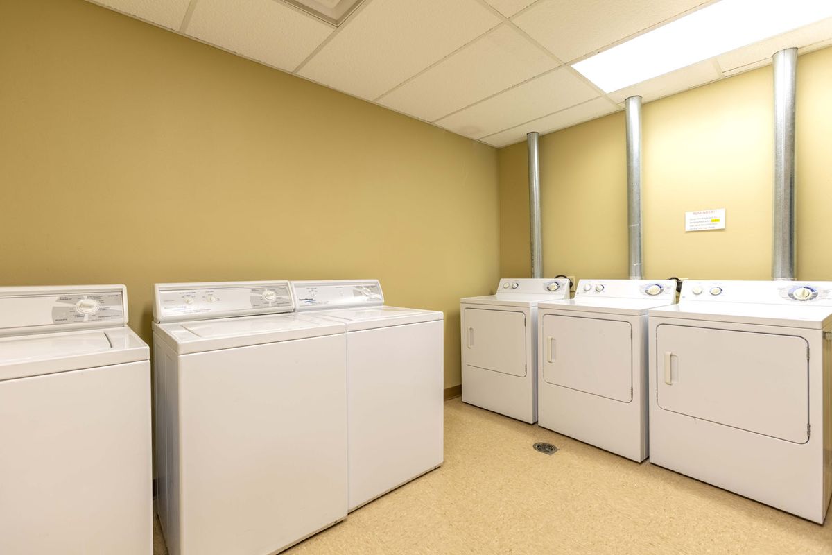 A laundry room with multiple washing machines and dryers.