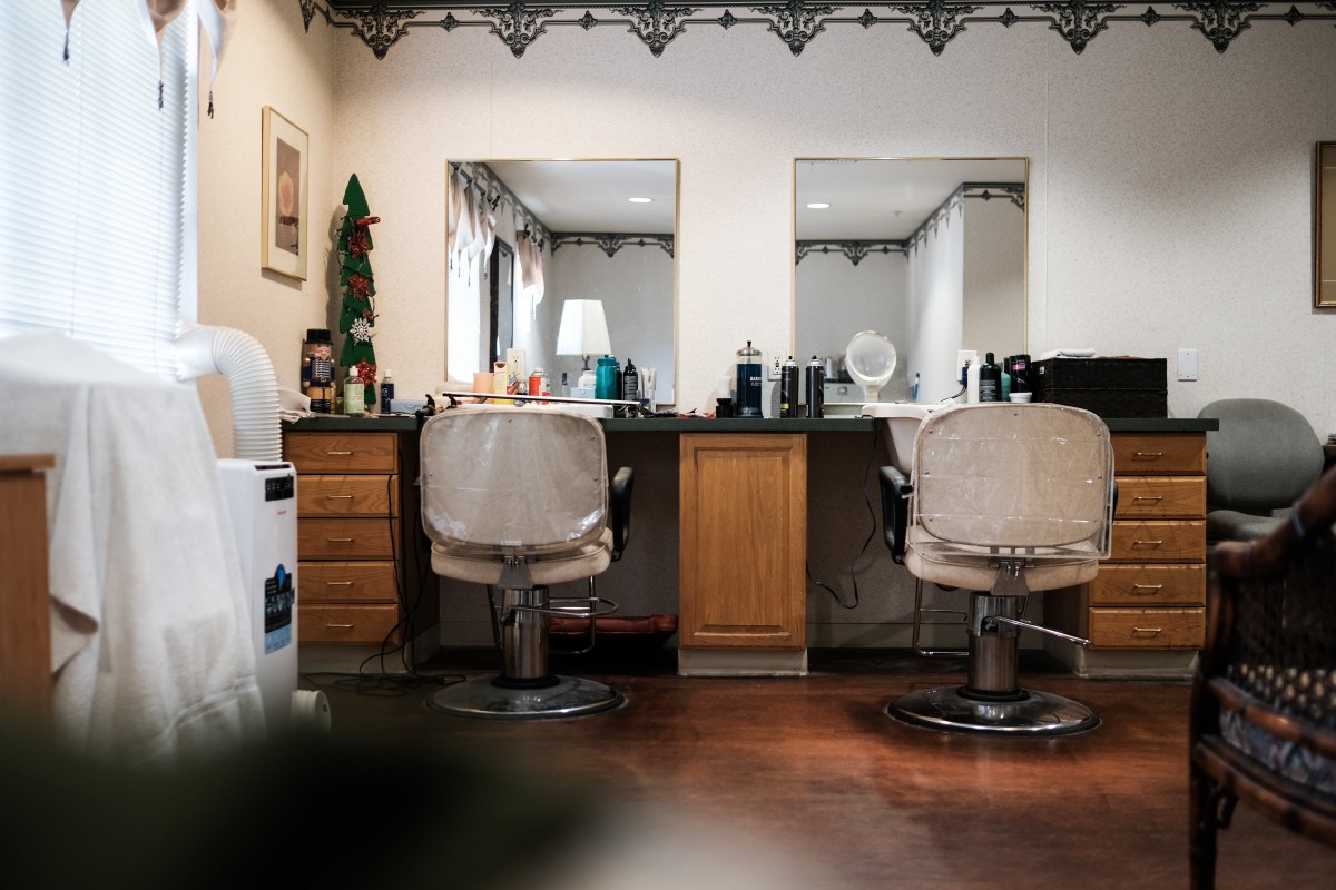 An interior view of a hair salon showing chairs and mirrors.