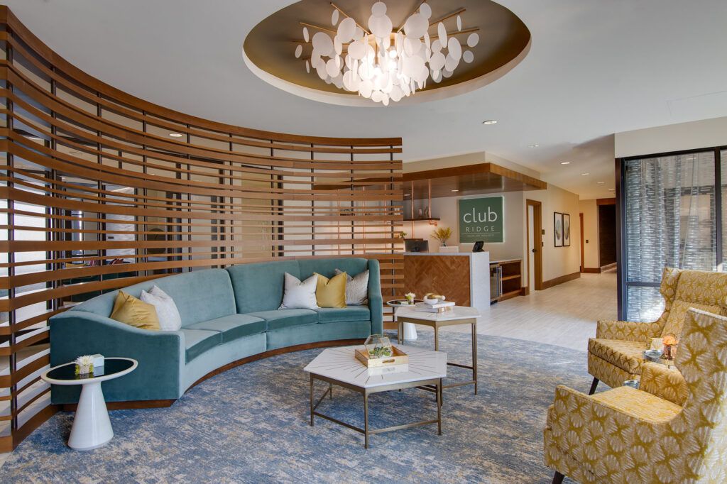 A modern lounge area featuring a circular sofa, elegant chandelier, and stylish decor.