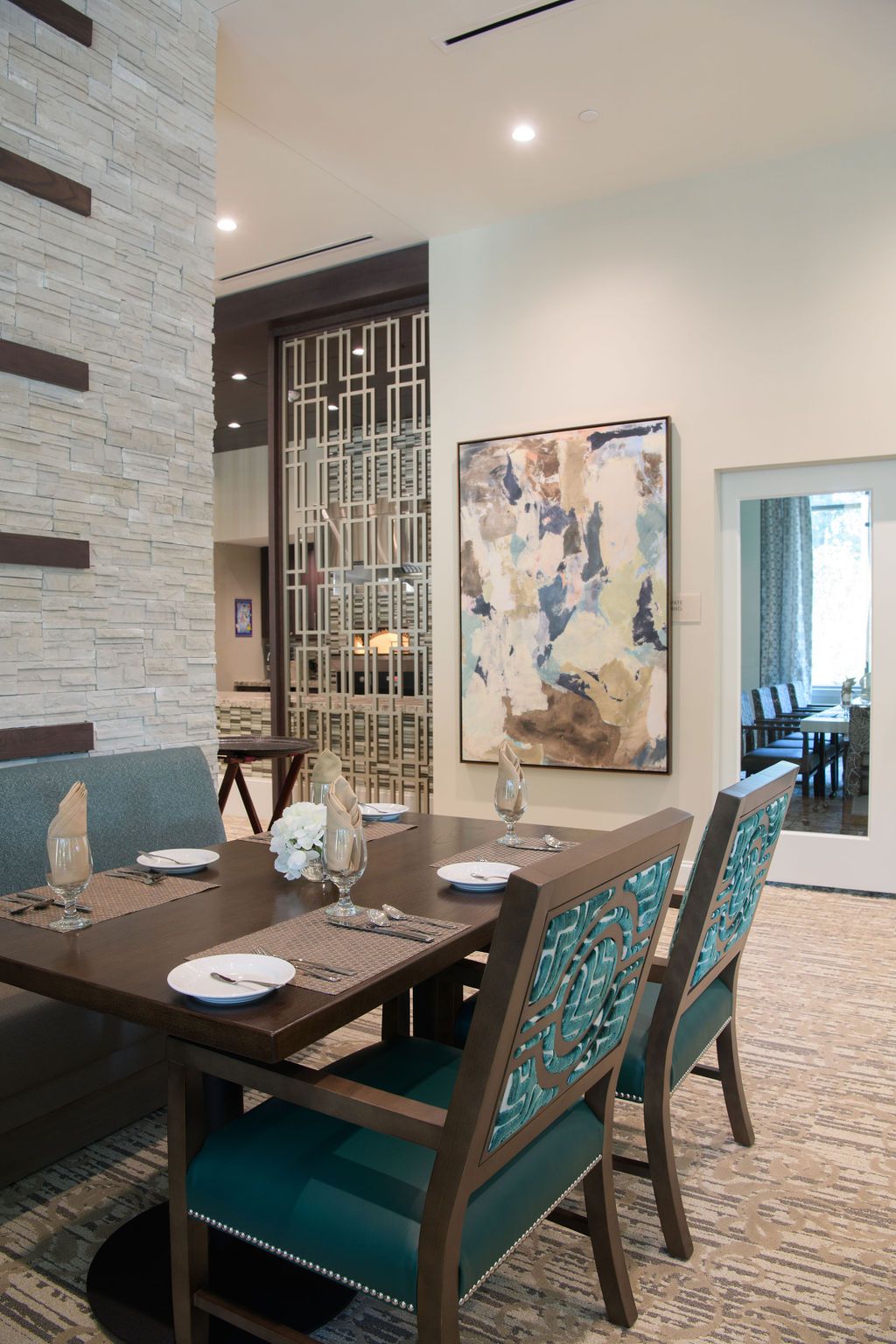 A modern dining room with elegant table settings and contemporary artwork.