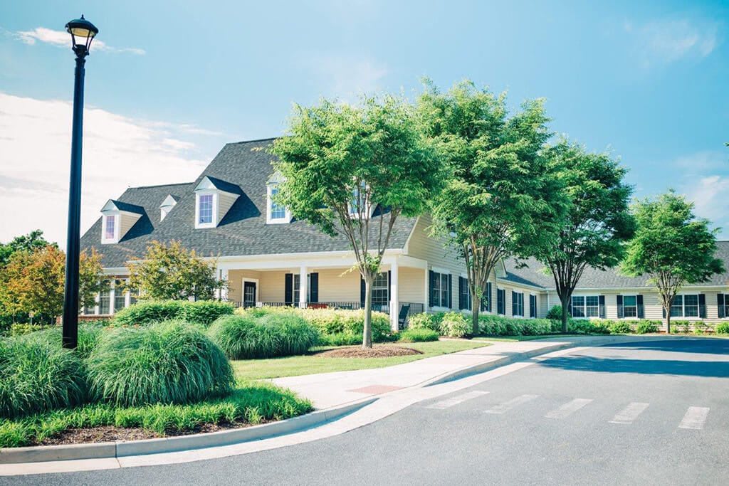 A suburban house with well-maintained landscaping and a driveway.